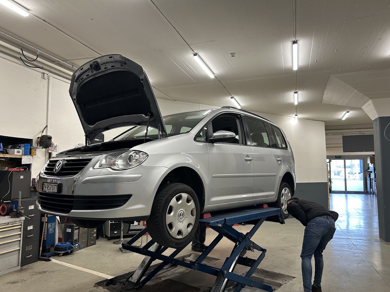 Mechaniker prüft ein Fahrzeug auf der Hebebühne in der Werkstatt